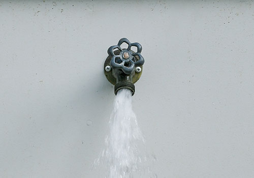 Outdoor hose bibb spigot with water running