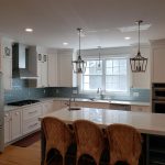 Kitchen renovation includes center island with chairs and all new stainless appliances and brushed nickel fixtures